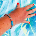 Adjustable braided coral-green cord bracelet with matching Lego brick